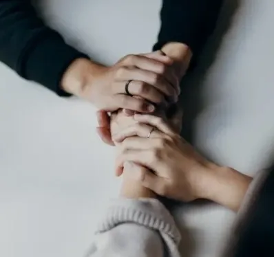 Two people holding hands across a table.
