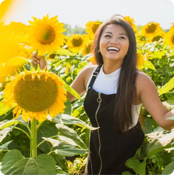 a lady on sunflower field smiling