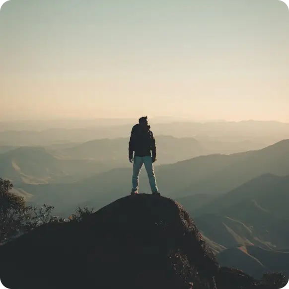 a man on top of a mountain looking at the horizon