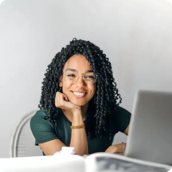 a woman with glasses and curly hair smiling