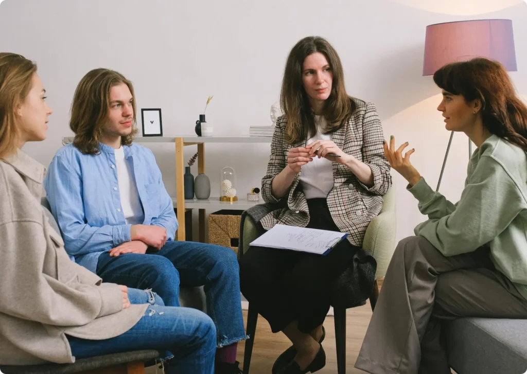 a man and a women talking to their therapists. one therapist has her notes on her lap.