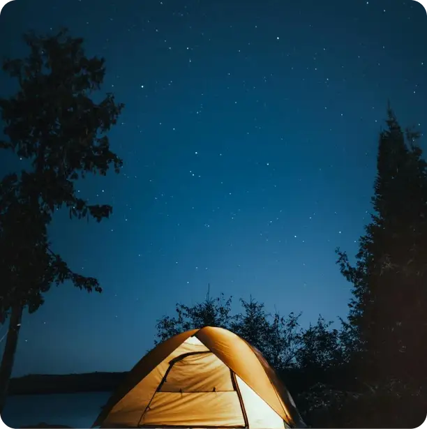 a tent with lights open with the stars as background