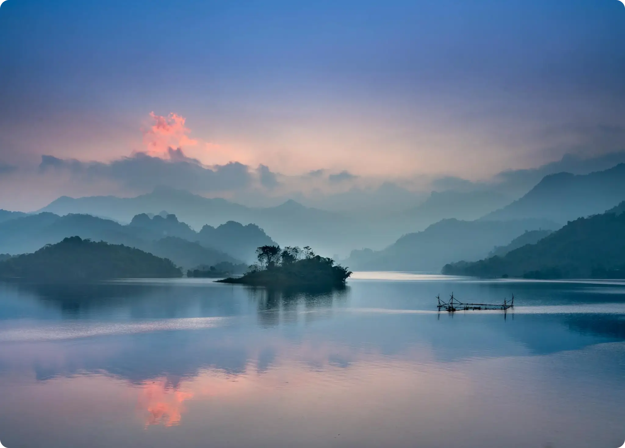 a river with an island in the middle and the mountains in the background