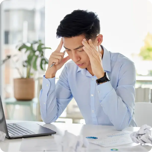 a man wearing office attire holding his head